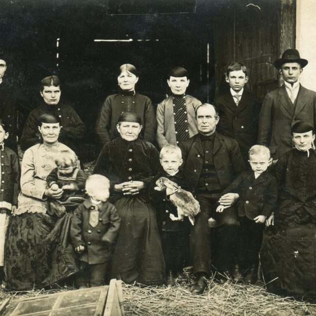 W otoczeniu najbliższych, w rodzinnym gospodarstwie w Raciborzu-Starej Wsi, pośrodku siedzą rodzice Paulina i Antoni Korczokowie, ksiądz Antoni Korczok stoi w drugim rzędzie, pierwszy z lewej. / Zbiory Teresy Wojak