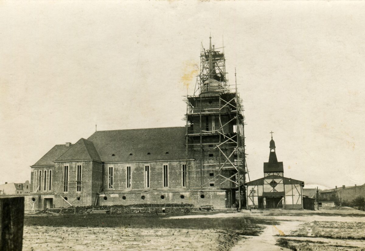 Kościół NMP Wspomożenia Wiernych w Gliwicach-Sośnicy w trakcie budowy w 1928 r. Z prawej strony widoczny tzw. kościół tymczasowy pw. Najświętszego Serca Pana Jezusa postawiony w 1911 r. i rozebrany po wybudowaniu nowej świątyni / Archiwum Parafii NMP Wspomożenia Wiernych w Gliwicach-Sośnicy